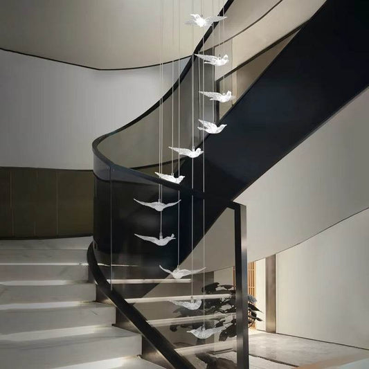 Modern bird acrylic chandelier with LED lights hanging in stairwell