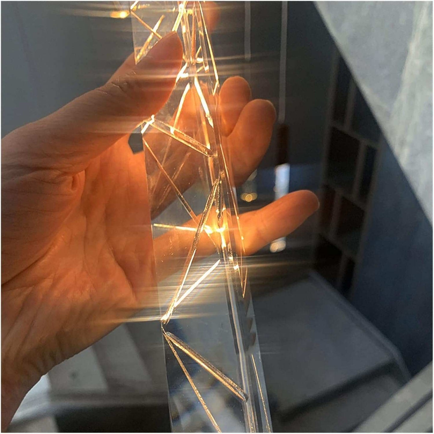 Close-up of a hand holding a glowing Checkered Staircase Chandelier crystal piece.