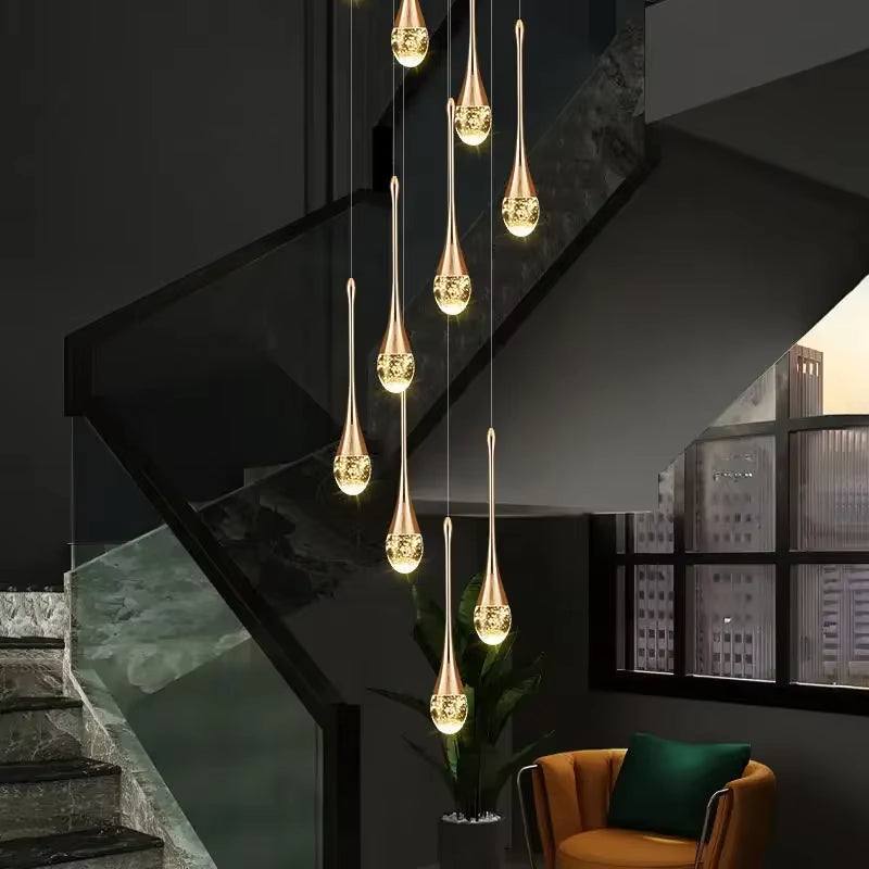 Modern gold long water drop chandelier with LED lights hanging in staircase area
