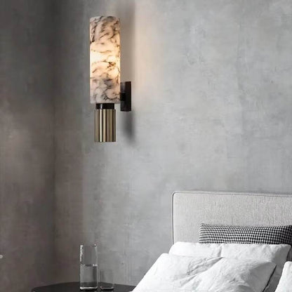 Natural marble sconce with black lamp body in bedroom setting.