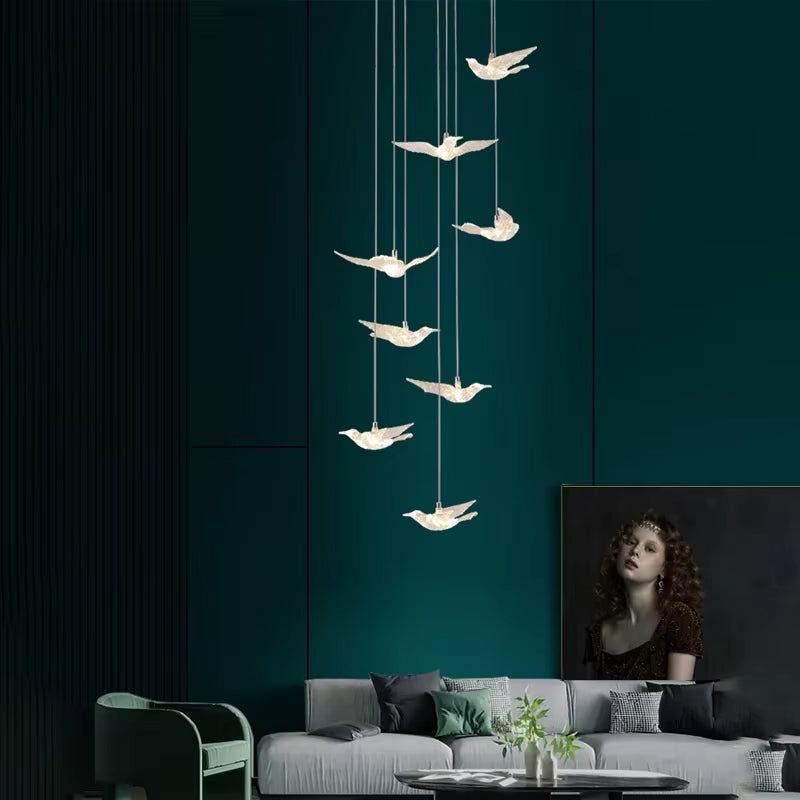 Elegant bird acrylic chandelier with LED lights hanging above living room sofa