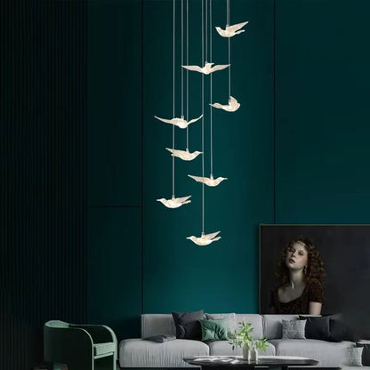 Elegant bird acrylic chandelier with LED lights hanging above living room sofa