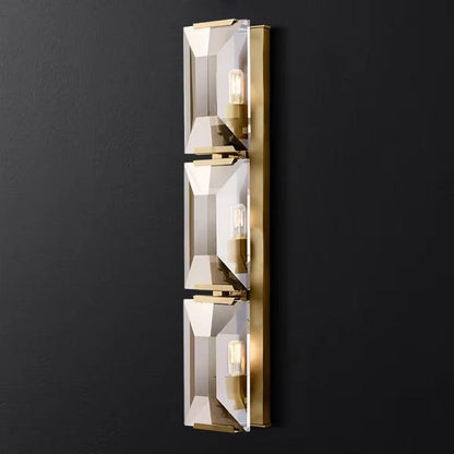 Modern crystal wall sconce with three lights and metal frame.