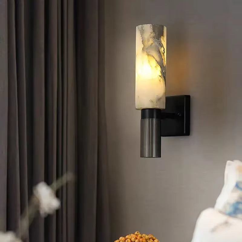 Natural marble sconce with black metal body and warm LED light, suitable for modern decor.