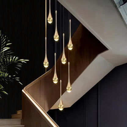 Modern long water drop chandelier with gold stainless steel and crystal design, LED lights, suspended in staircase area