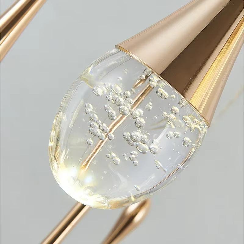 Close-up of modern gold stainless steel and crystal long water drop chandelier LED light bulb detail