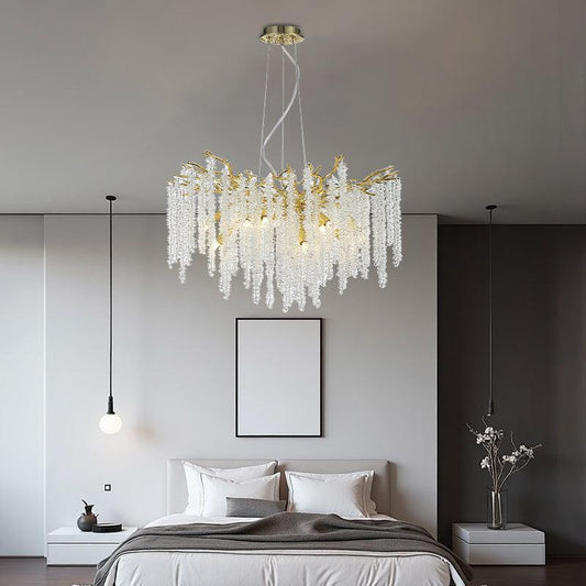 Vintage tree branch chandelier with crystals in a modern bedroom setting.