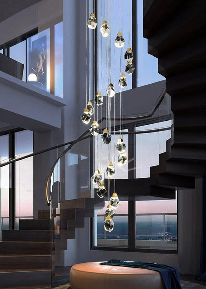 Modern crystal stone staircase chandelier in gold finish, featuring hanging crystal stones and spiral staircase setting.