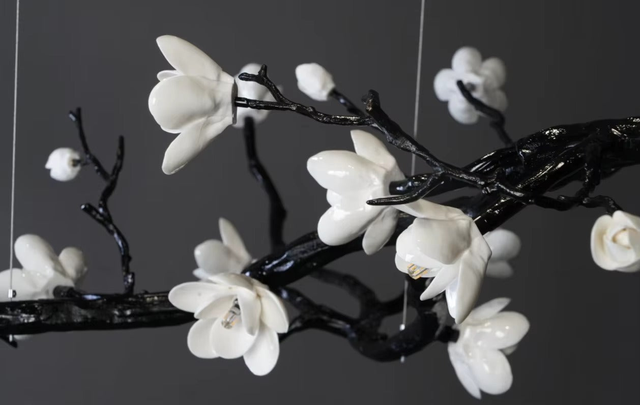 Close-up of a ceramic flower design on a deluxe brass chandelier, showcasing modern, minimalist style.